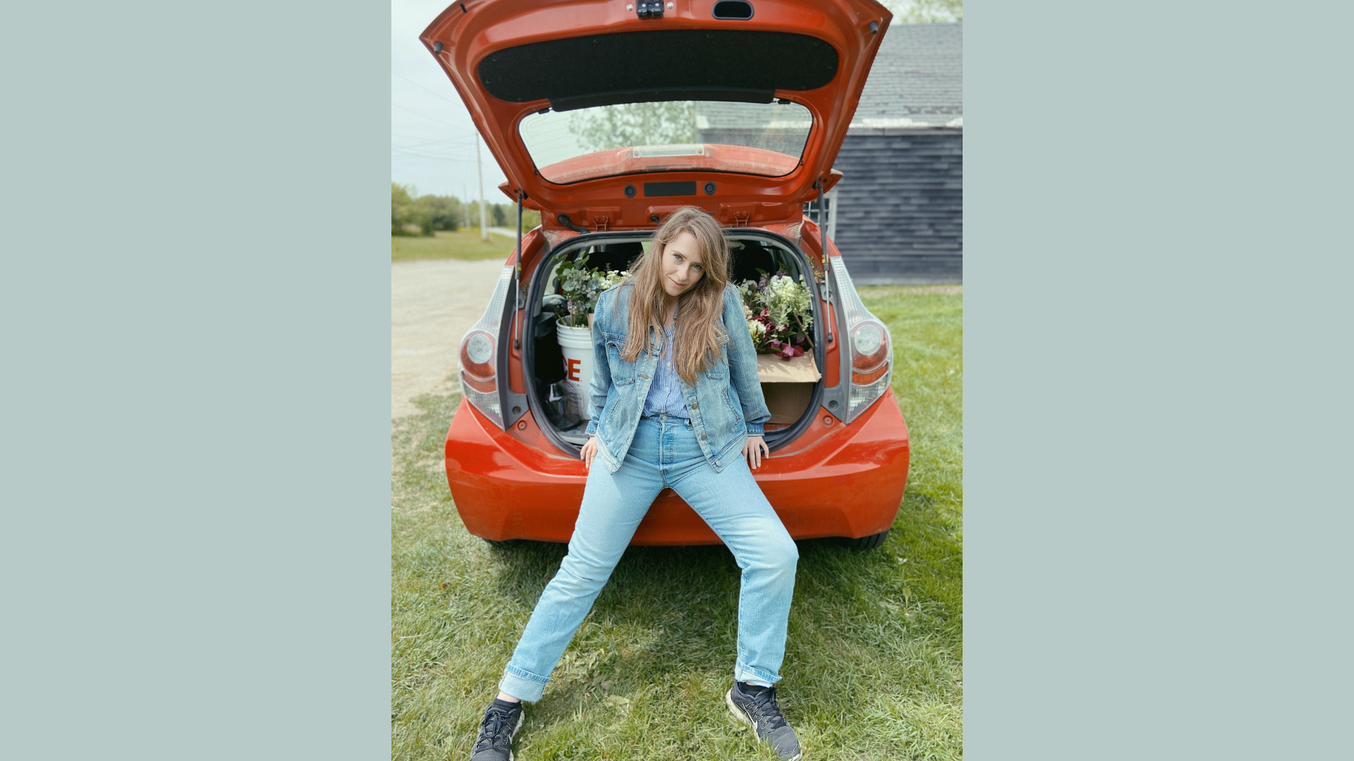 Meet the Member: Capture the essence of Eos Designs Studio with a vibrant image—one of their team members, styled casually in denim, perches on the open trunk of a car filled with trendy boxes and lush plants. This inviting scene perfectly embodies their creative spirit and innovative approach. Perfect for inspiring curiosity and engagement online!.