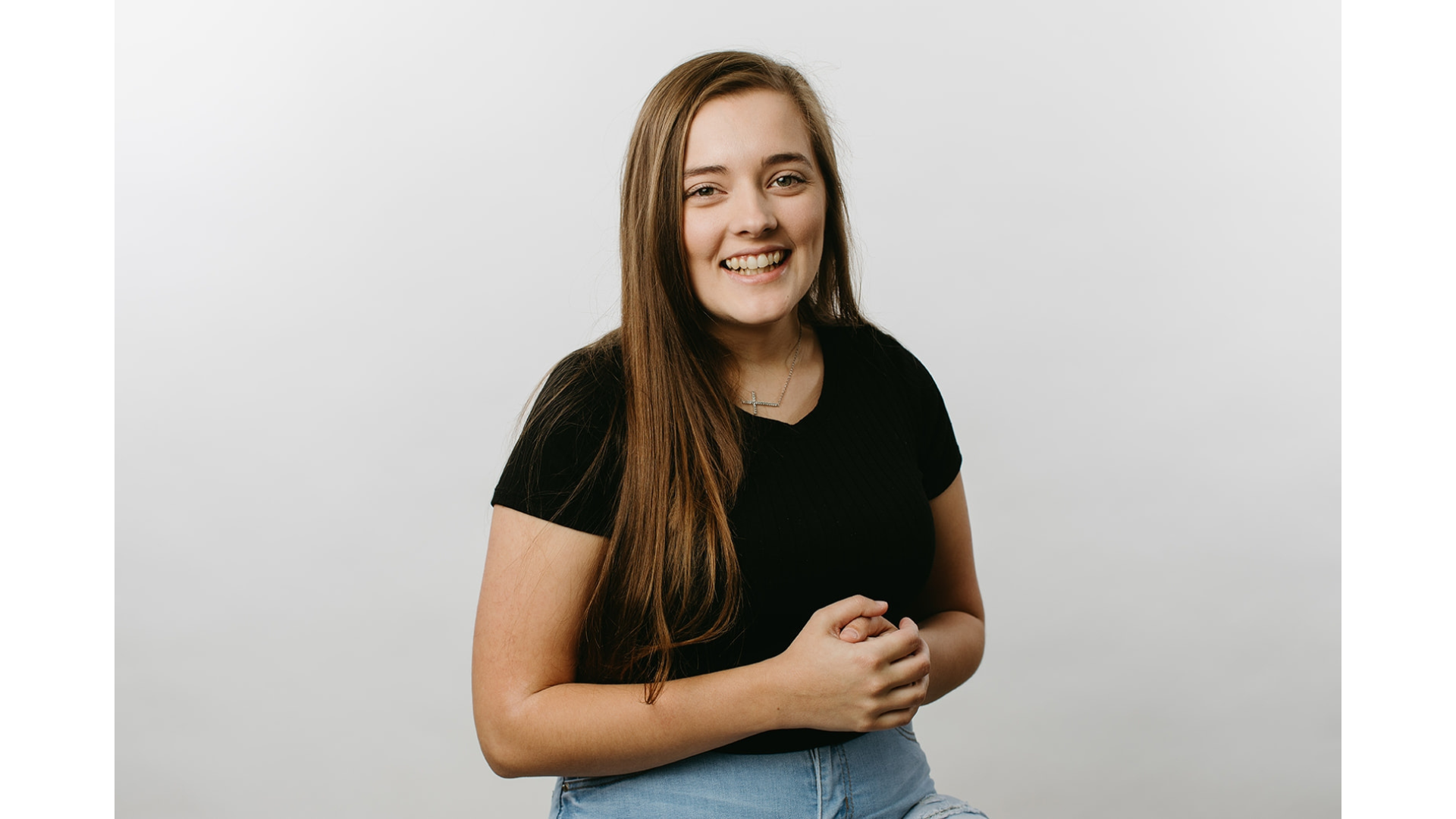 Introducing: Meet the Member! With long hair, a sleek black shirt, and jeans, they effortlessly embody understated elegance. Their style subtly echoes the charm of Floral Baby Design. Smiling against a simple white background, they capture a clean and timeless look that resonates with modern flair.