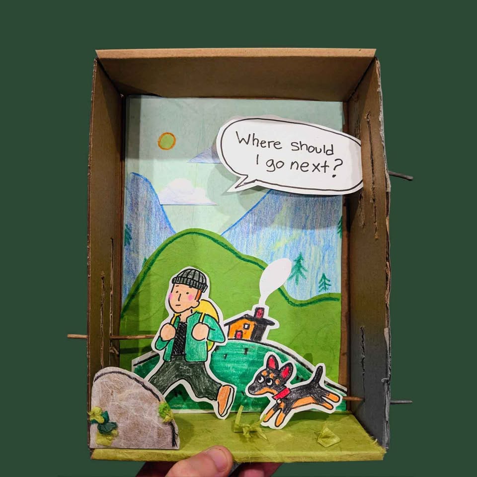 Discover adventure in every step with our handmade diorama featuring a whimsical cartoon explorer and their loyal dog, hiking against a scenic backdrop of mountains and a cozy house. The playful speech bubble asks, "Where should I go next?"—sparking imagination and wanderlust in anyone who sees it. Perfect for travel lovers, hikers, or unique home decor enthusiasts.