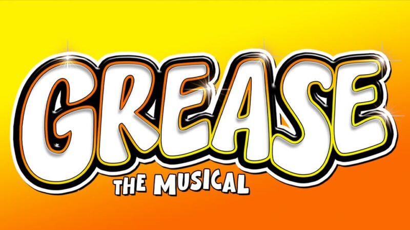 Bright, bold “GREASE” shines in white with black and yellow outlines above lively yellow “THE MUSICAL,” glowing on a sunburst orange-yellow backdrop—capturing our community’s creative spark and inviting everyone to join the fun!.