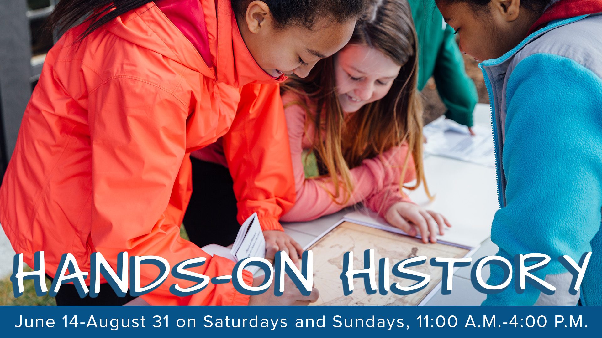 Three kids in bright jackets beam as they discover history together, hands-on at our vibrant outdoor map table. Join us—June 14–Aug 31, weekends, 11am–4pm! Text: "HANDS-ON HISTORY.