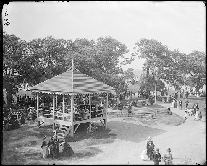 Neighbors gather in and around a gazebo, relaxing on benches under shady trees, bikes parked nearby—our creative Salem Willows spirit shines.