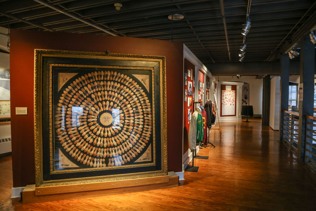 Sure! Here’s a revised, SEO-friendly alt text that’s concise, accessible, and captures your community-focused brand voice: Alt text: Our vibrant gallery glows with hardwood floors and local art—a bold circular piece shines on a burgundy wall, celebrating our creative community. Let me know if you'd like further tweaks or have more details to highlight!.