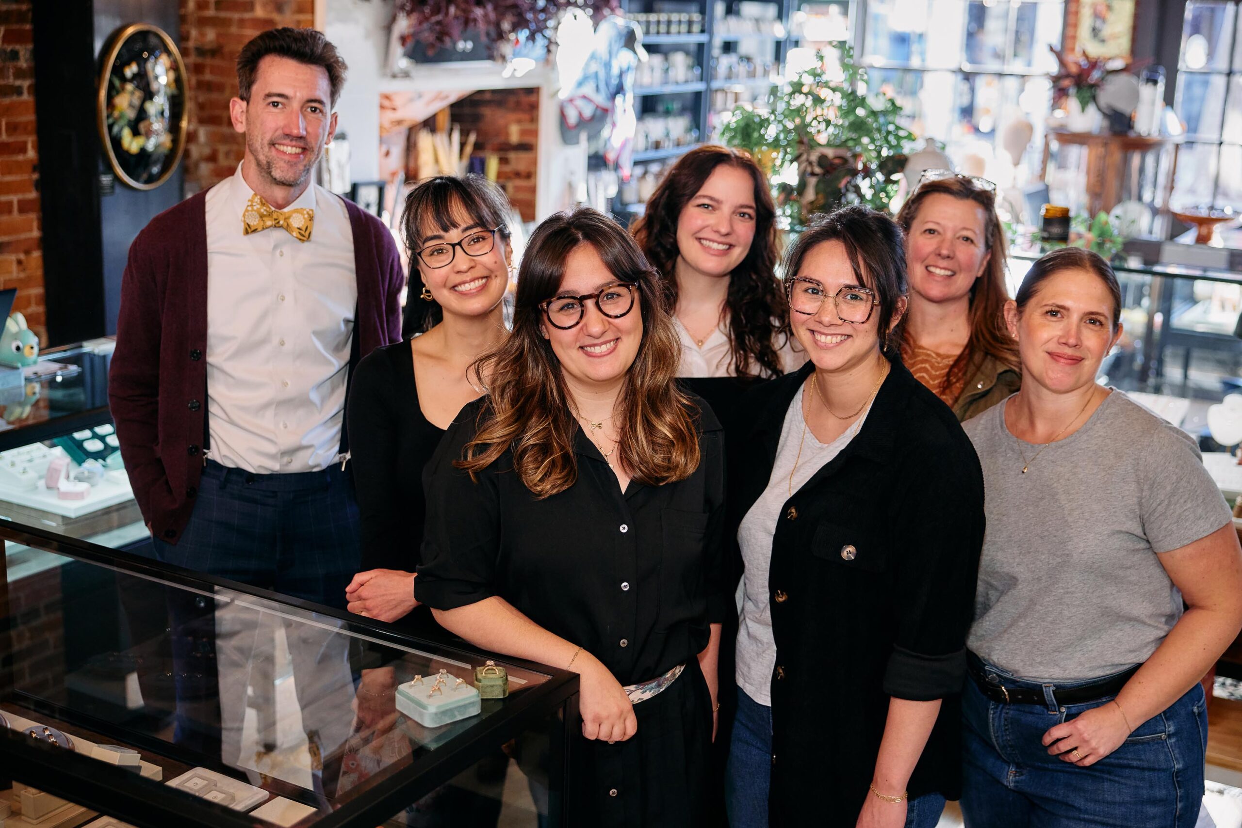 Seven adults, beaming with pride, gather in a lively Essex County shop—showcasing local creativity and strong community ties.