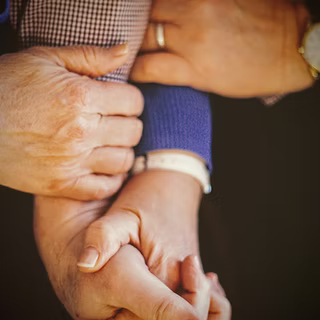 Hands and arms of three people from Essex County intertwined, a watch and ring visible, radiate vibrant unity and creative community care.