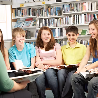 Teens gather in a lively circle at the library, sharing books and ideas. Shelves burst with stories, sparking Essex County's creativity.