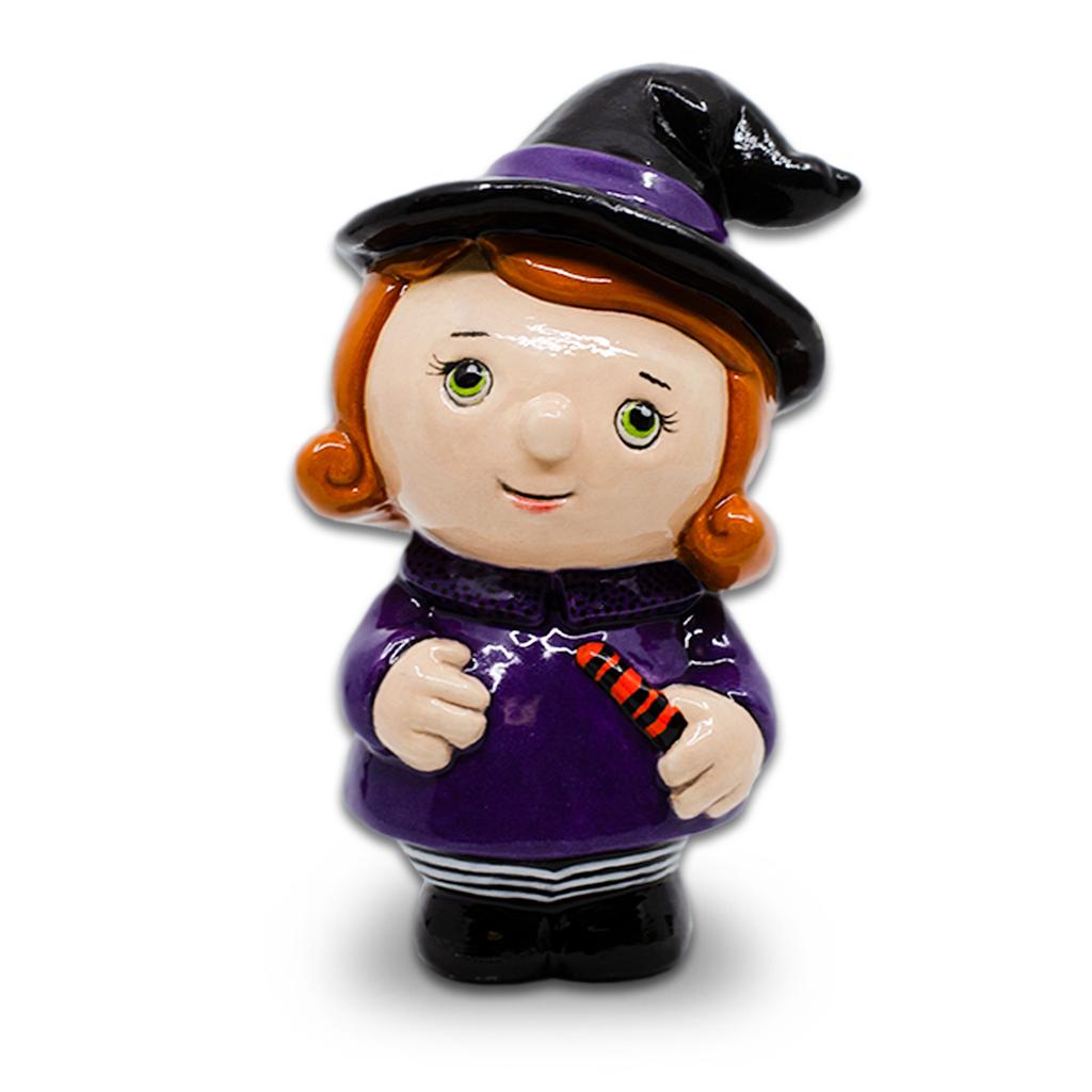 A lively ceramic witch figurine with bright green eyes, orange hair, and a purple outfit—sparking local Halloween creativity in Essex County.