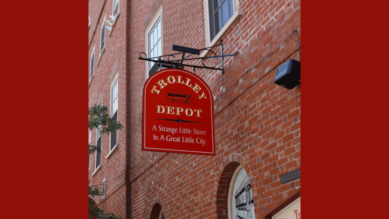 A vibrant red Trolley Depot sign with a charming trolley and playful slogan celebrates creativity and community spirit in Essex County.