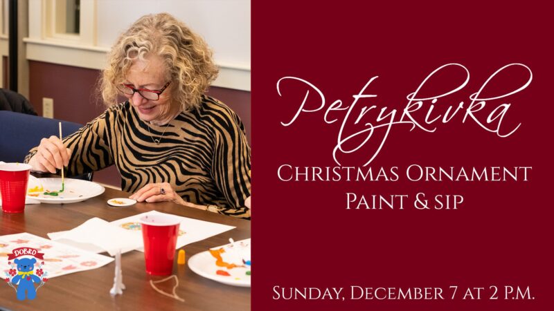 A joyful woman paints a festive Christmas ornament at a lively art table, inviting Essex County to our creative Ornament Paint & Sip!.