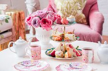 A lively tea table buzzes with sandwiches, pastries, and bright floral china—where Essex County neighbors connect over creativity.
