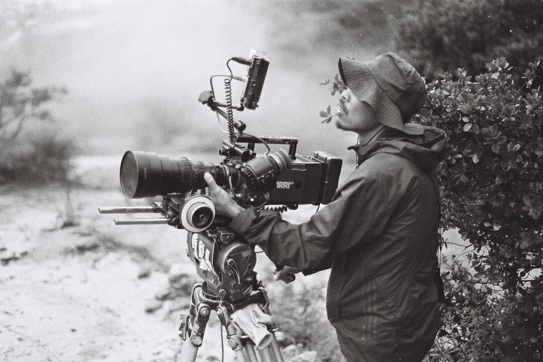 A creative filmmaker in a rain jacket captures Essex County’s natural beauty, connecting community stories on a misty day.