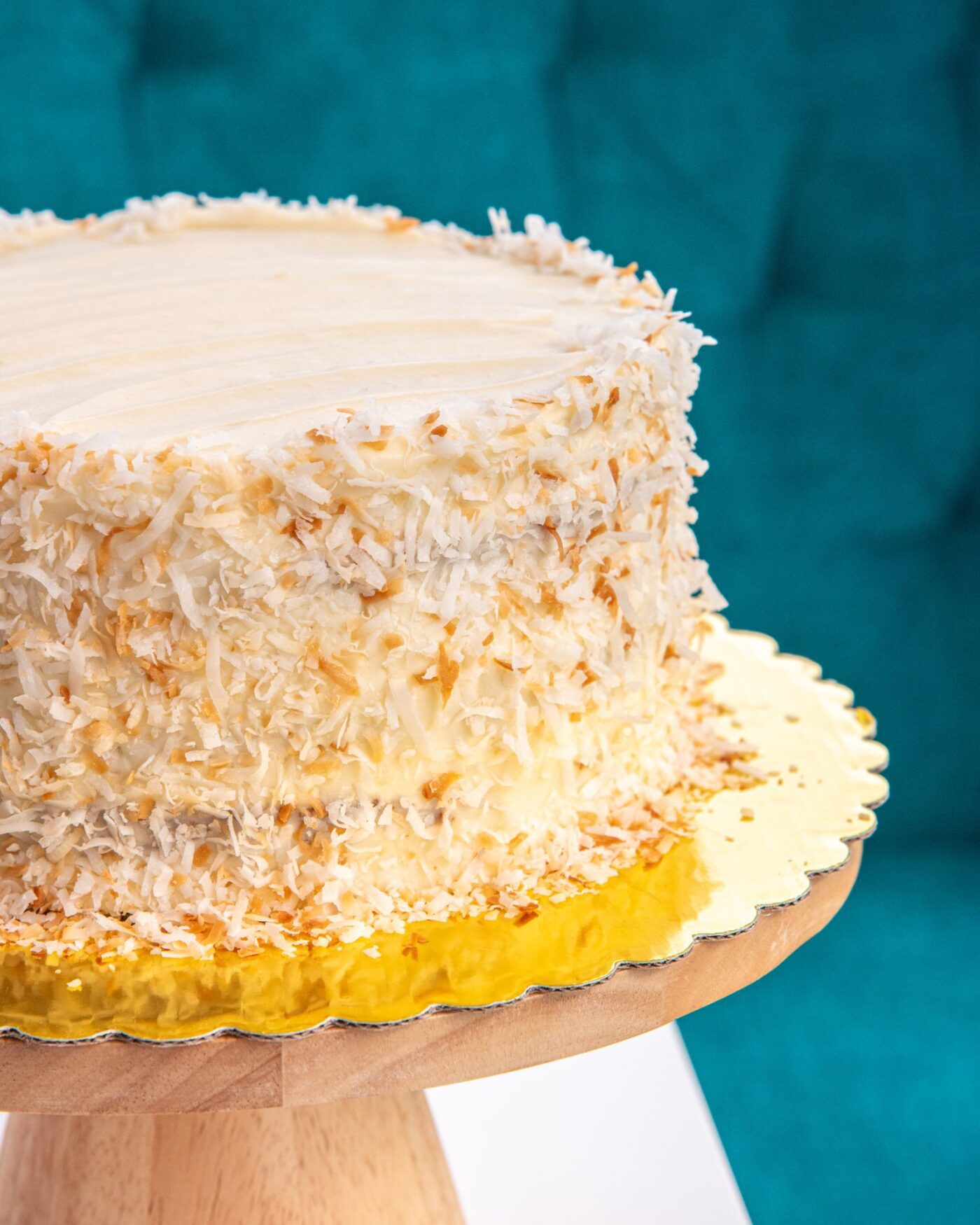 A festive cake with snowy coconut topping shines on a gold board, inviting Essex County to celebrate creativity together.