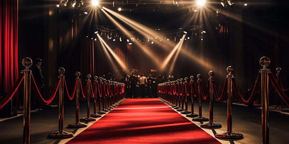 A vibrant red carpet with gold stanchions welcomes our creative Essex County community, gathering brightly under spotlights.