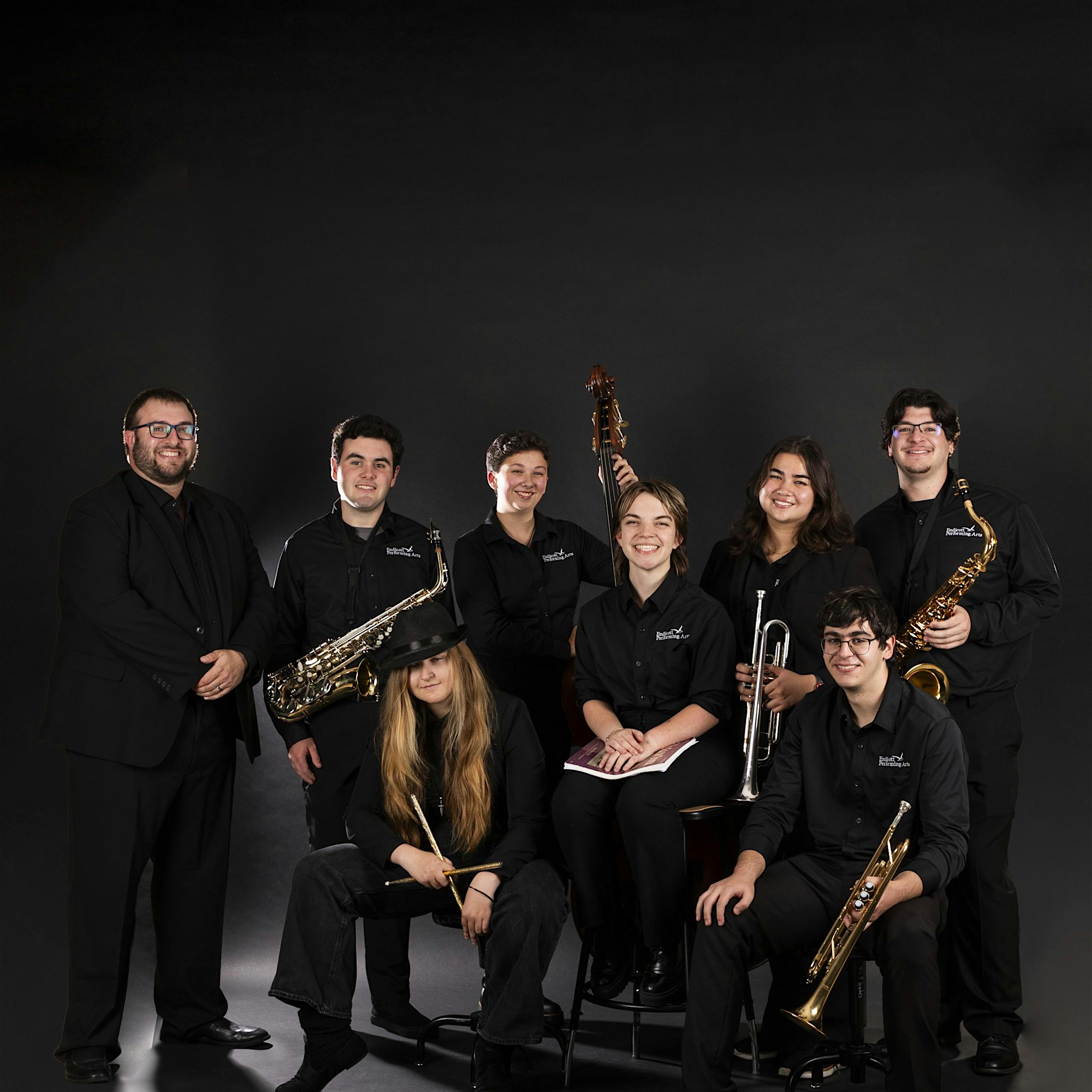 Eight Essex County musicians unite, radiating creativity and local pride as they pose with instruments, ready to inspire community.