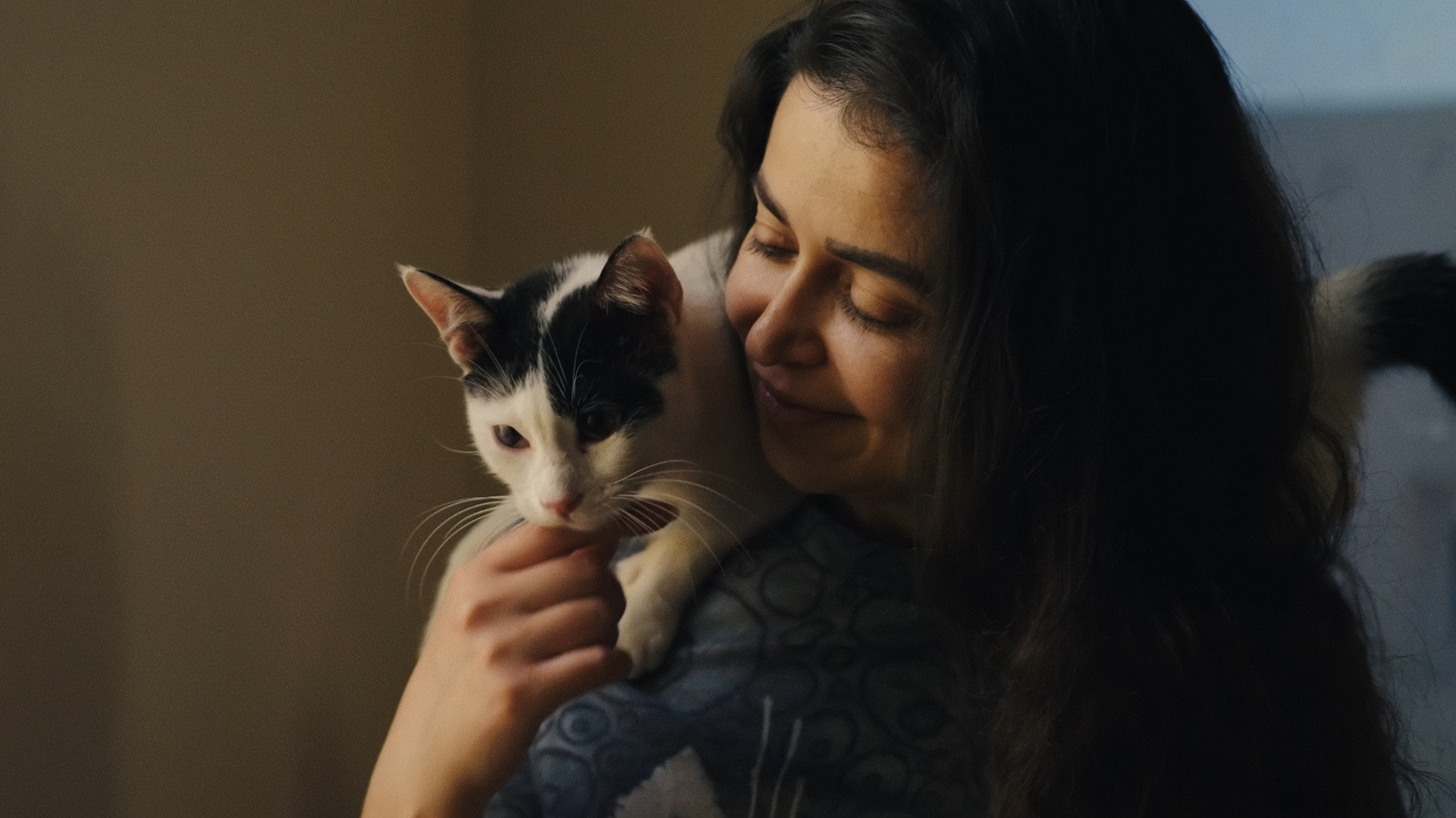A creative Essex County woman shares a joyful moment with her black and white cat, radiating warmth and local community spirit.