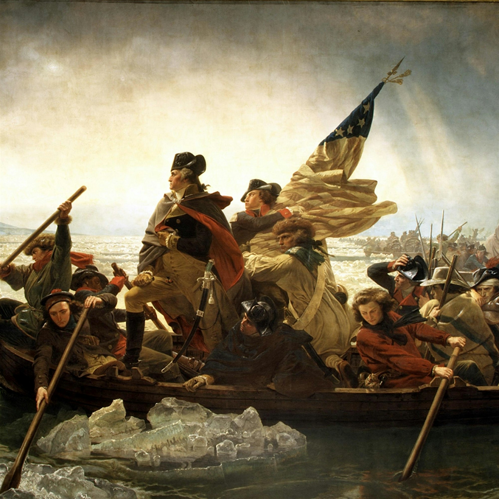 A group of men in colonial-era clothing row a wooden boat through icy waters, with one man standing and holding a telescope while another holds an American flag. The scene is set in winter with broken ice in the river.