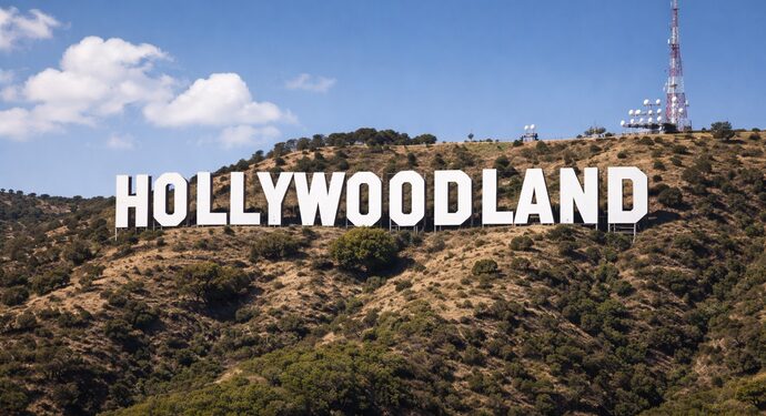 Bold "Hollywoodland" letters crest a lively hillside, uniting the creative community beneath a vibrant, cloud-streaked sky.
