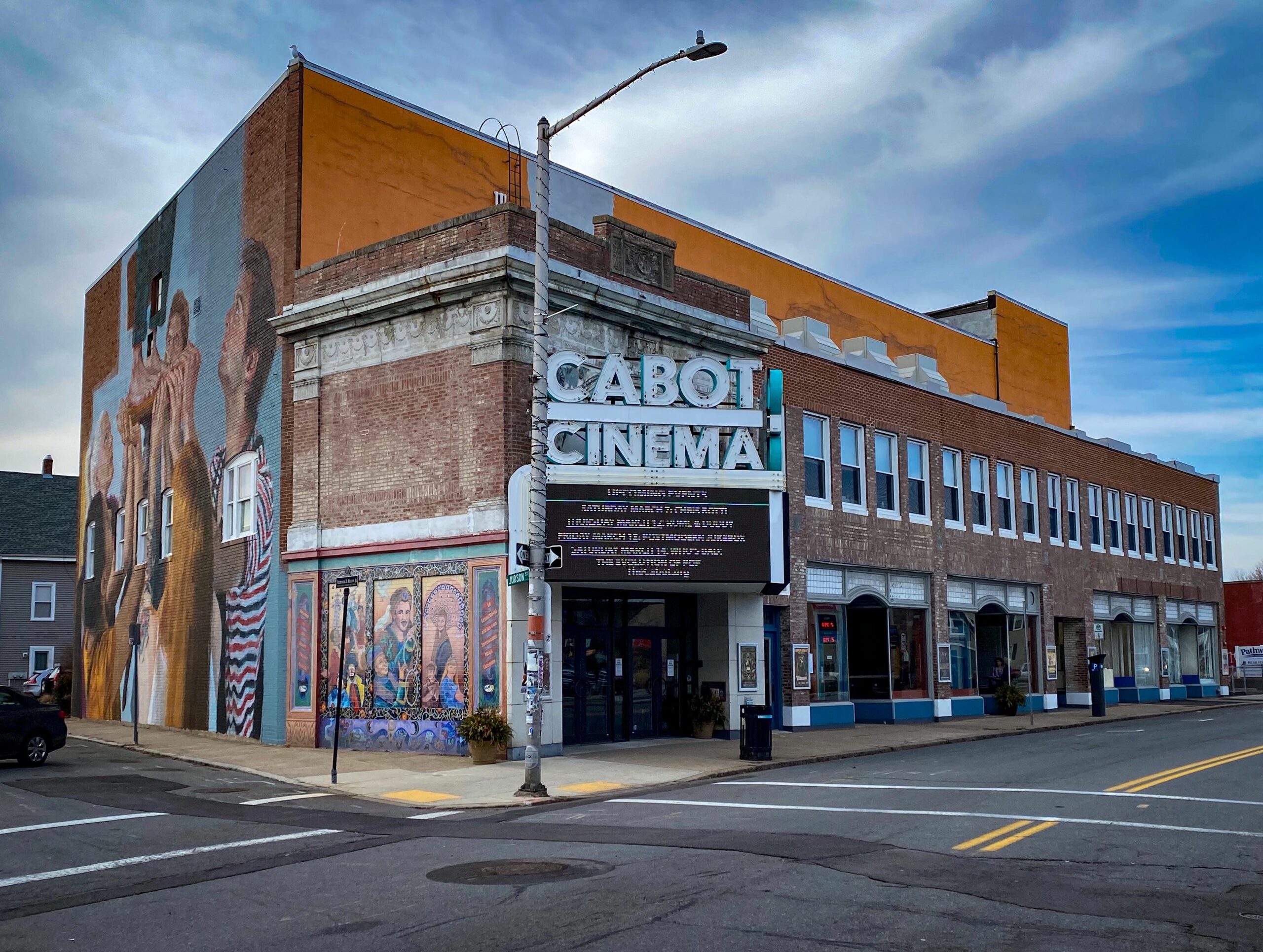 The vibrant Cabot Cinema, with bold murals and a glowing marquee, anchors Beverly’s lively arts scene—a creative Essex County hub.