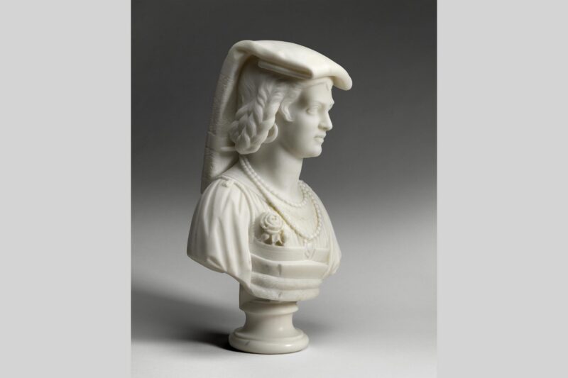 Marble bust of a woman wearing a draped headdress, braided hair, and layered clothing with a brooch and necklace, shown in profile view on a round pedestal against a neutral background.