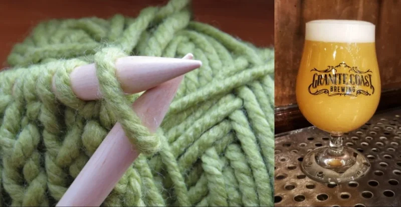 Close-up of green yarn and wooden knitting needles on the left, with a glass of hazy beer on the right—perfect for a Sip n Knit session. The beer glass features the "Granite Coast Brewing" logo, all set on a metal surface.