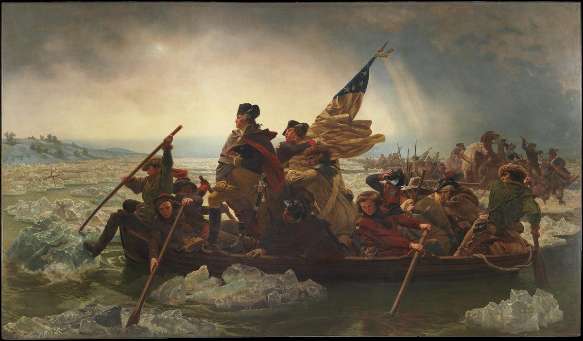 A group of men in historical military clothing row a small boat across an icy river, carrying a large U.S. flag. One man stands near the center, looking ahead, while others paddle through floating ice. The sky is cloudy and dramatic.
