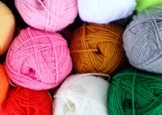 Balls of yarn in various colors, including pink, white, orange, green, gray, and yellow, are grouped closely together—perfect for Grades K-2 handwork or fiber arts projects.