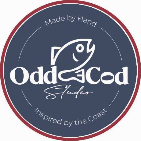 A circular Odd Cod Studio logo with a maroon border and blue center features a fish illustration, the name "Odd Cod Studio," and the phrases "Made by Hand" and "Inspired by the Coast" in smaller text along the border.