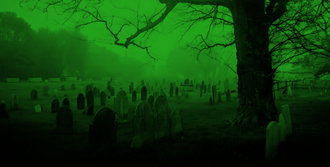 A graveyard with numerous headstones, a large tree in the foreground, and mist in the background. The entire scene is tinted green, giving it an eerie appearance.