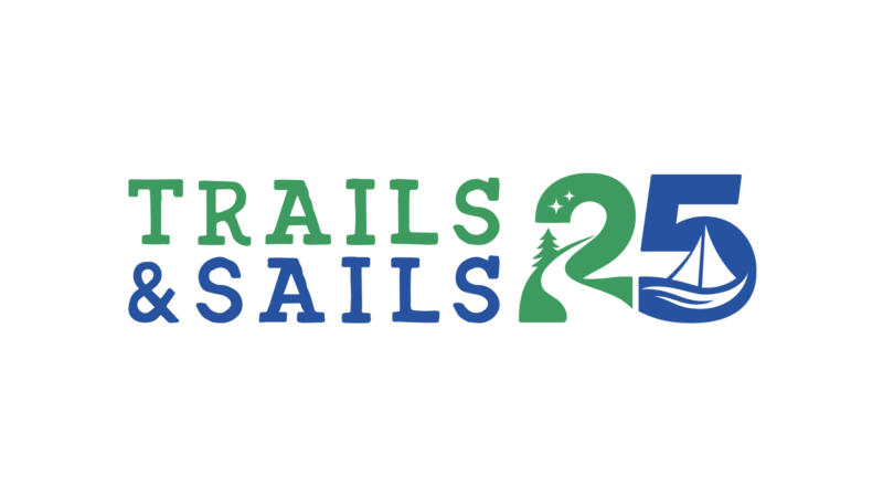 Logo reading "Trails & Sails 25." The number 2 features a path, tree, and stars, while the 5 includes a sailboat on water. Colors are green and blue.
