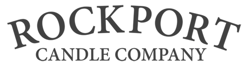 Logo for Rockport Candle Company. The words "ROCKPORT" appear in large, curved uppercase letters above "CANDLE COMPANY" in smaller uppercase letters. The text is black on a light gray background.