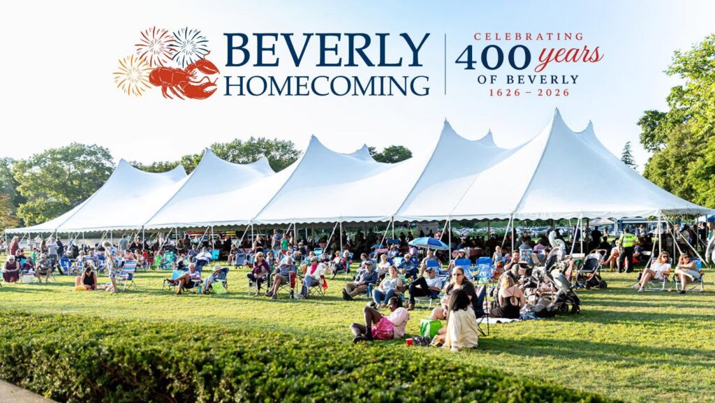 A large white tent shades rows of people at an outdoor Homecoming Party. Signs announce “Beverly Homecoming” and “Celebrating 400 Years of Beverly 1626-2026.” Trees and blue sky frame the community celebration.