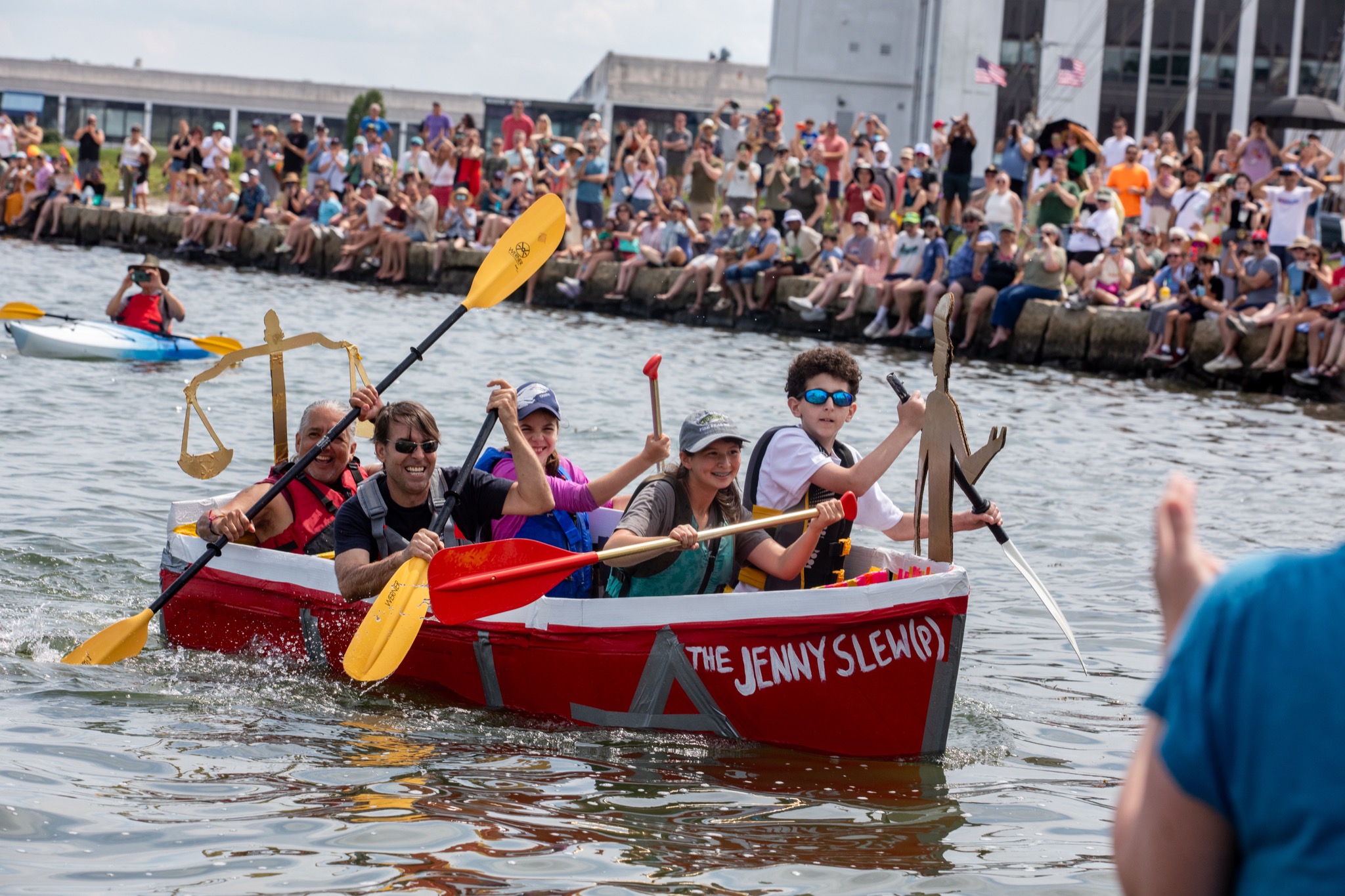 Crew of the Jenny Slew cardboard boat raising their paddles in celebration at the Salem 400 Cardboard Regatta
