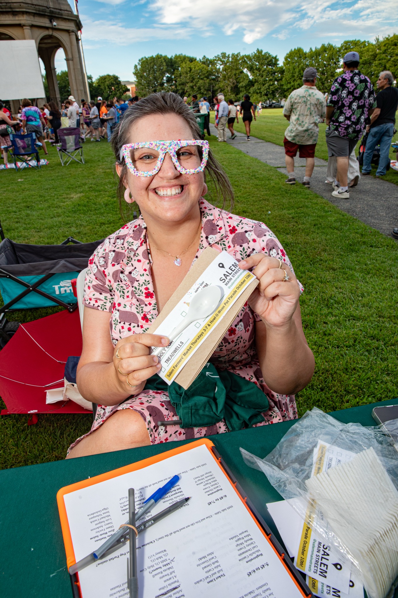 A volunteer handing out spoon kits at check-in at the Ice Scream Bowl on Salem Common