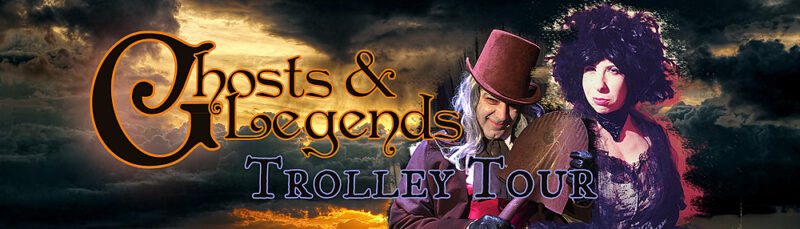 A man in Victorian clothing and a woman in a dark dress and hat stand against a stormy sky. Text reads “Ghosts & Legends Trolley Tour.” The image suggests a theatrical or historical tour with a spooky theme.