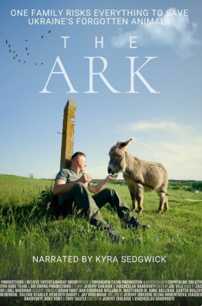 A man sits in a grassy field feeding a small donkey near a tall stone marker at Critter Fest. Birds fly above. White text gives the film title “The Ark,” features a tagline about Ukraine’s animals, and notes it’s narrated by Kyra Sedgwick.