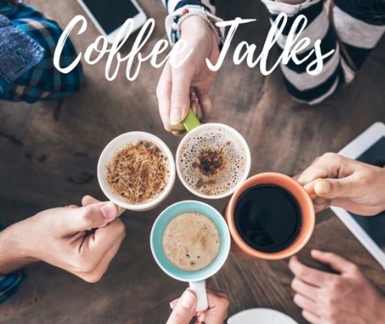 Four people hold mugs of coffee in a circle over a wooden table with electronic devices, as “Coffee Talks” is written in white script above. Gather inspiration for your next visit to North Shore Children’s Museum at this relaxing meet-up.