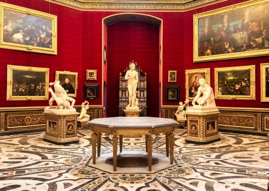 A museum gallery with red walls features classical statues, framed paintings, and ornate decor. A round table is in the center, surrounded by marble floors with intricate patterns and sculptures on pedestals.