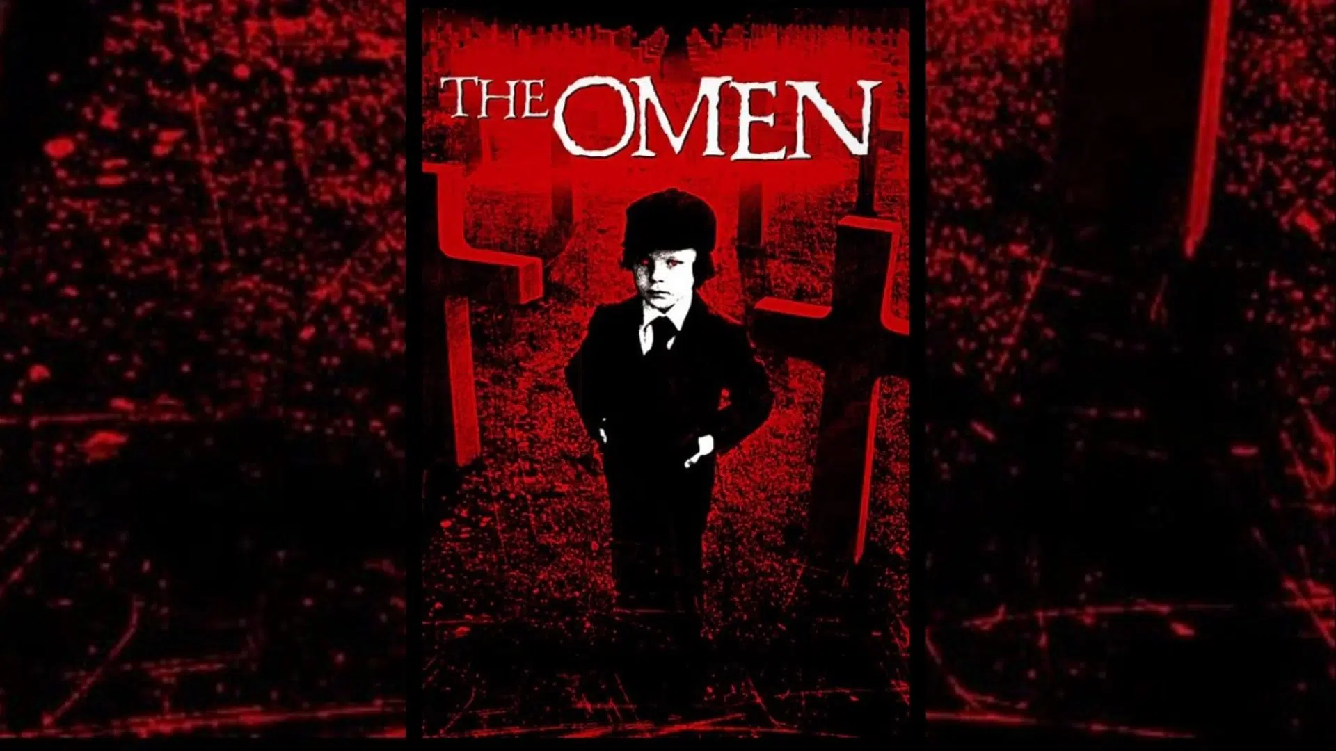 A movie poster for the 1976 horror film “The Omen” shows a young boy in a suit and hat standing before red crosses in a graveyard. Set against a dark red and black background, the film title appears at the top in white, Gothic-style letters.
