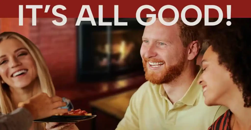Three people laughing and enjoying good food together with the text “IT’S ALL GOOD!” overlaid at the top.