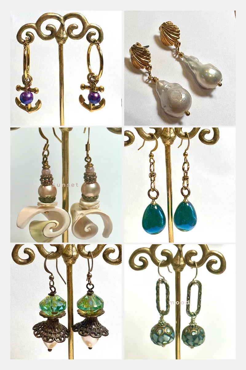A collage of six pairs of dangling earrings, including anchor-shaped charms, baroque pearls, spiral shells, and colorful beads displayed on gold stands.