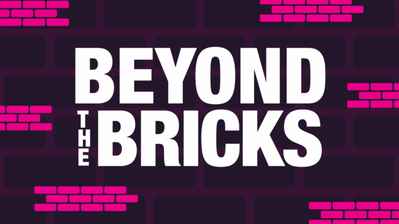 Text reading “BEYOND THE BRICKS” in white, bold, sans-serif font against a dark background with scattered pink brick outlines, evoking themes of building community.