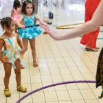 a little girl is holding a hula hoop.