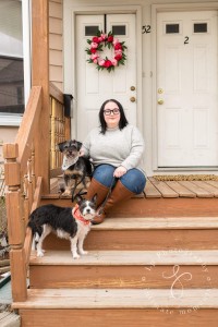 a woman sitting on the steps with two dogs.