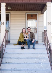 a man and woman sitting on the steps of a house.
