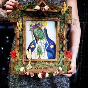 a woman holding a picture frame with a painting of a woman.