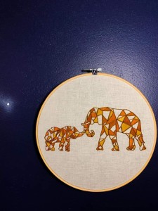 a cross stitch picture of an elephant and its baby.