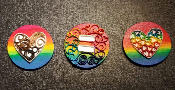 three wooden buttons with different designs on them.