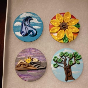 four decorative magnets of different shapes and sizes.