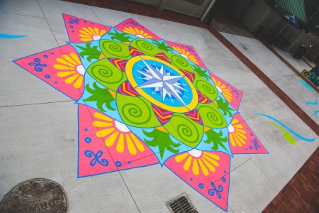 a colorful design on a sidewalk with a fire hydrant.