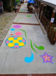 a sidewalk painted with colorful designs on it.